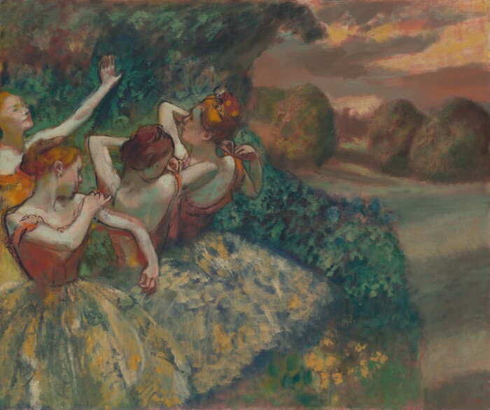 Four ballet dancers in orange skirts adjusting their straps before a stage.