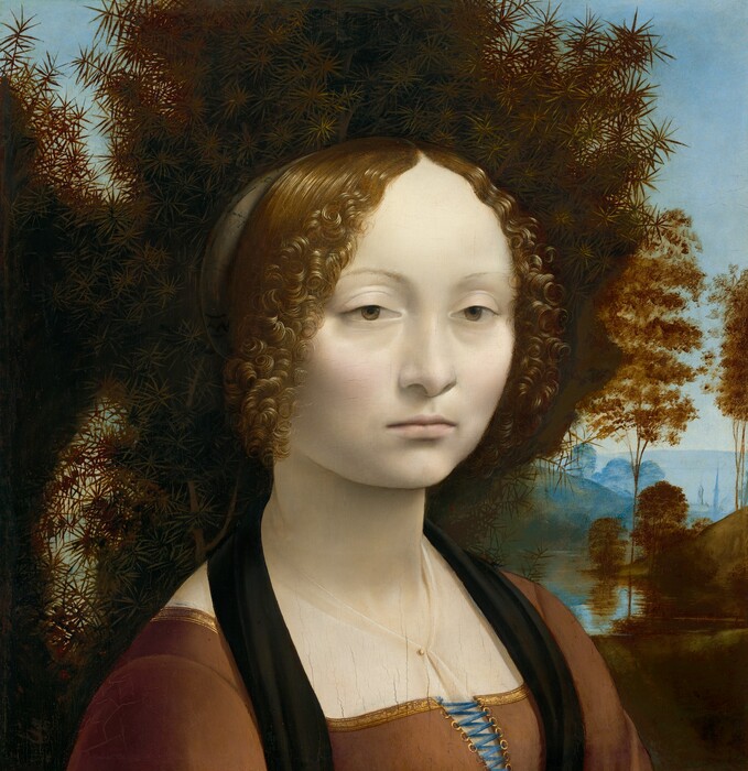 Portrait of a pale young woman with tight curls before a juniper bush.