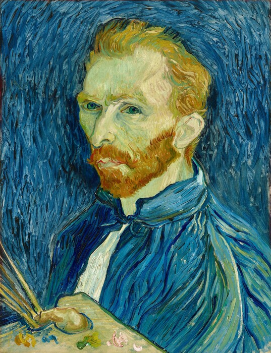 The artist in a blue jacket against a swirling pale blue background.